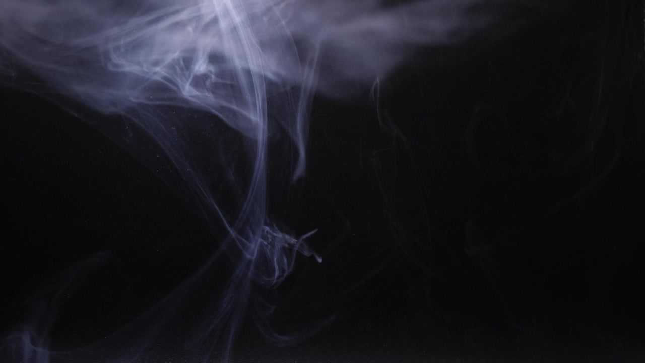Vortici grigi di fumo su sfondo nero, primo piano, ripresa 4k, messa a fuoco selettiva.