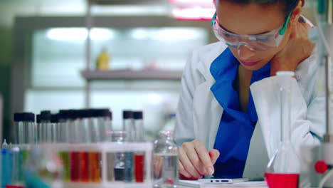 estudiante de química mirando el móvil. mujer química desplazándose por el teléfono