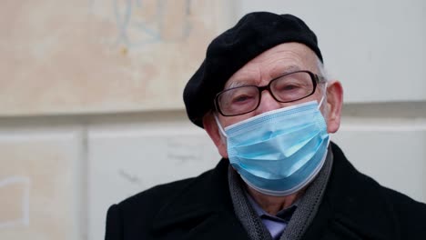 old grandfather in a medical mask outdoors to avoid getting infected with the virus. prevention of viral diseases. loneliness of old people