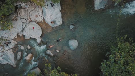 drone aerial, top view of a natural river with people swimming in colombia