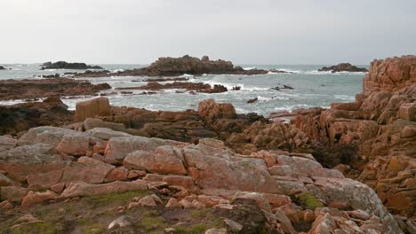 imágenes a través de la bahía de olas blancas espumantes chocando contra rocas lejanas luego llegando a tierra suavemente en la orilla rocosa con vistas al mar