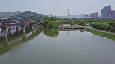 una filmación aérea dinámica moviéndose hacia una carretera sobre las aguas en yuen long en hong kong