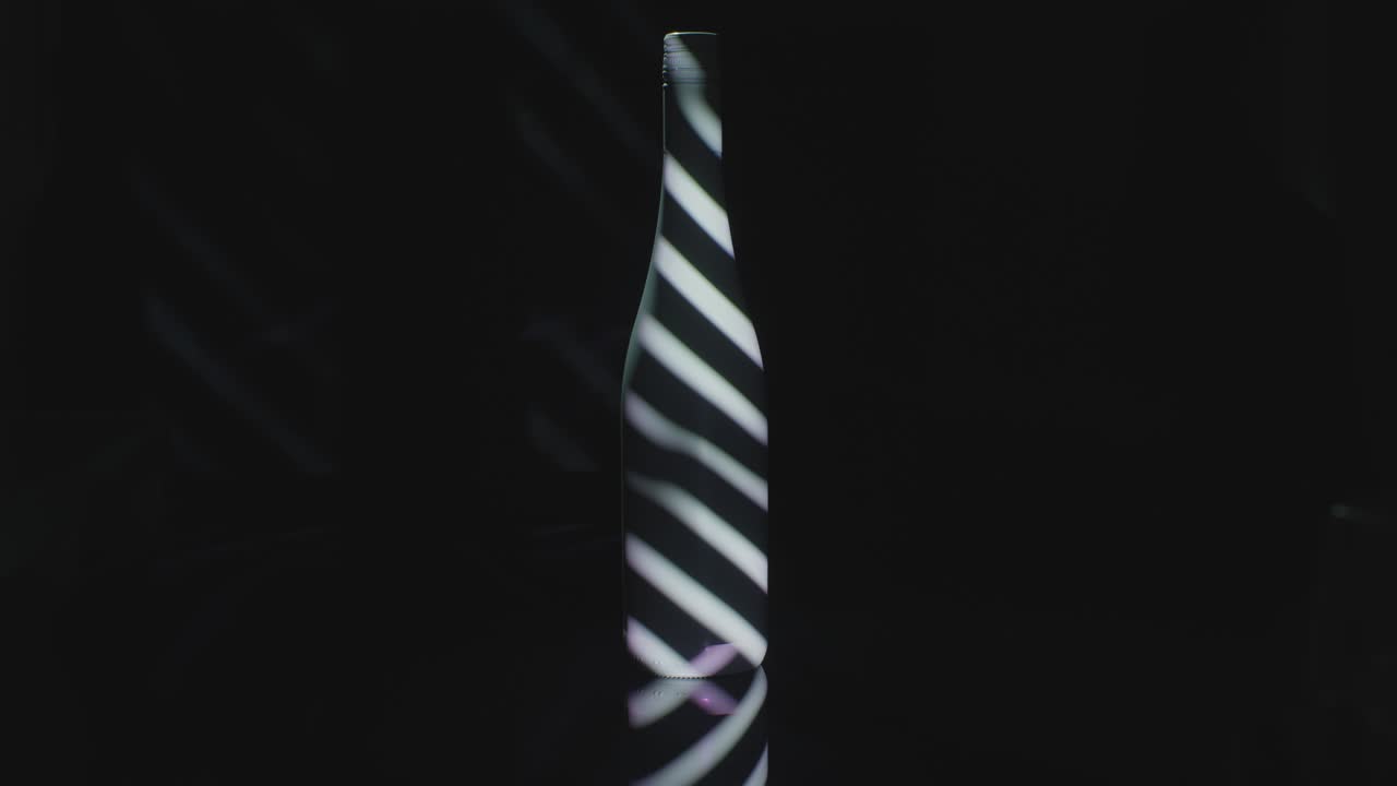 barras de luz proyectadas en una botella de vino oscuro