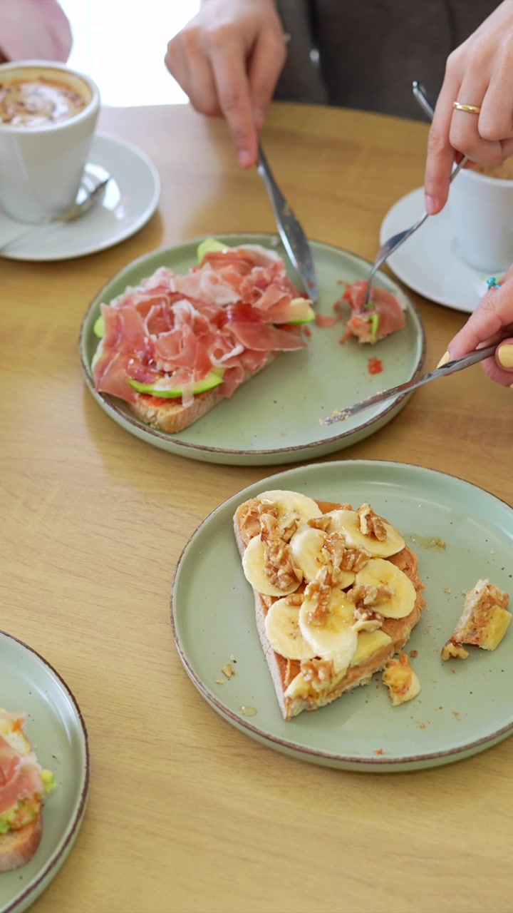Amici che gustano toast salutari e caffè al bar per colazione