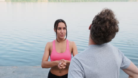 Happy-Sportive-Couple-Warming-Up-And-Stretching-Near-The-River-1