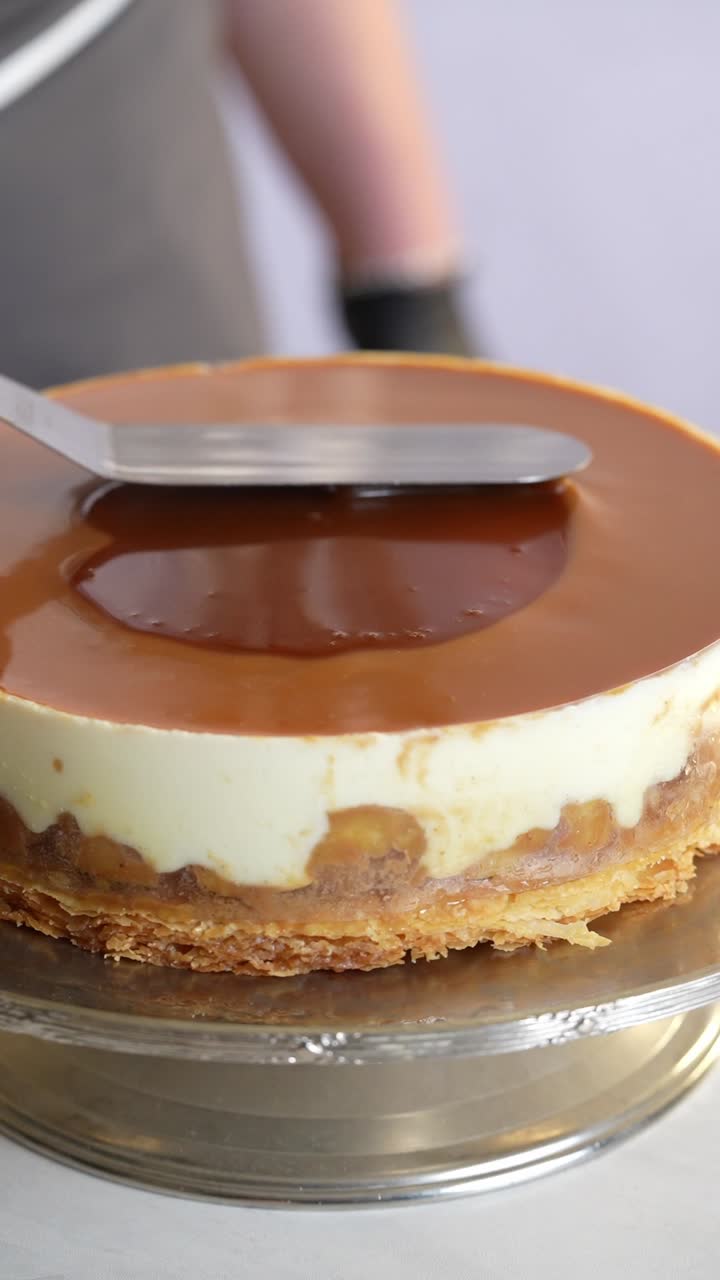 A chief put a caramel sauce to a cake, close up shot, insert shot