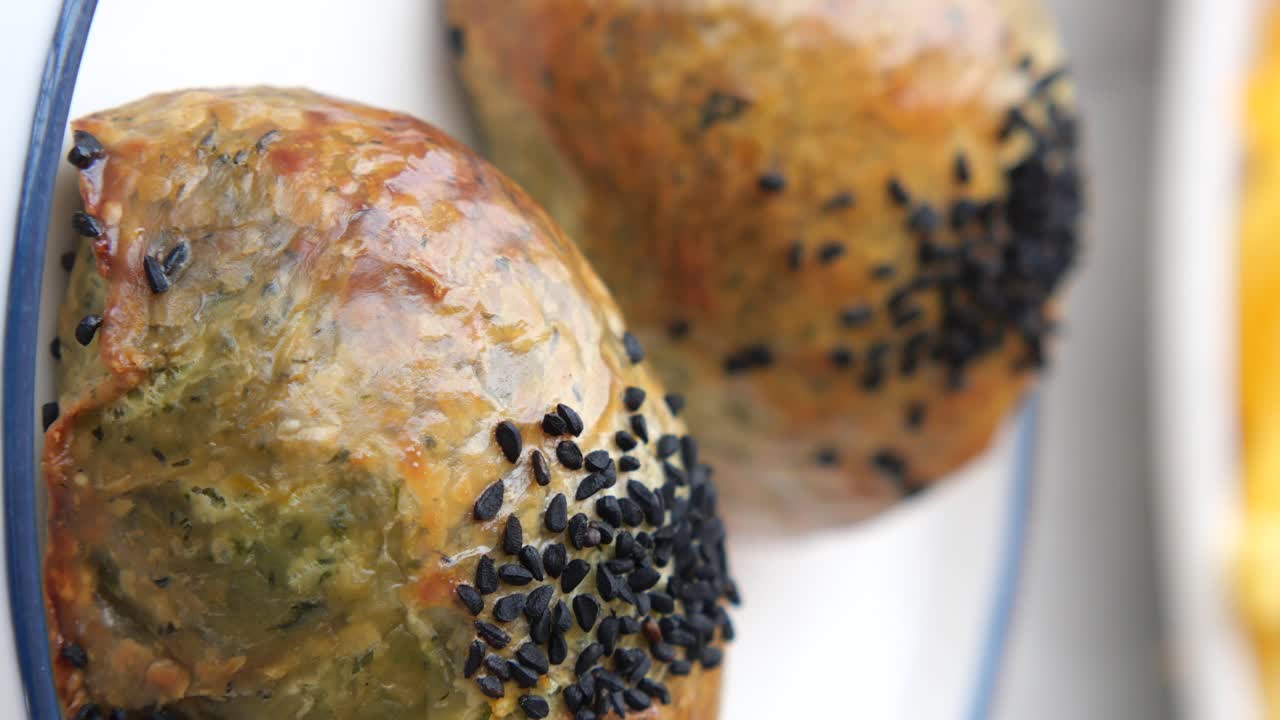 Close-Up of Savory Pastries with Green Filling and Black Sesame Seeds