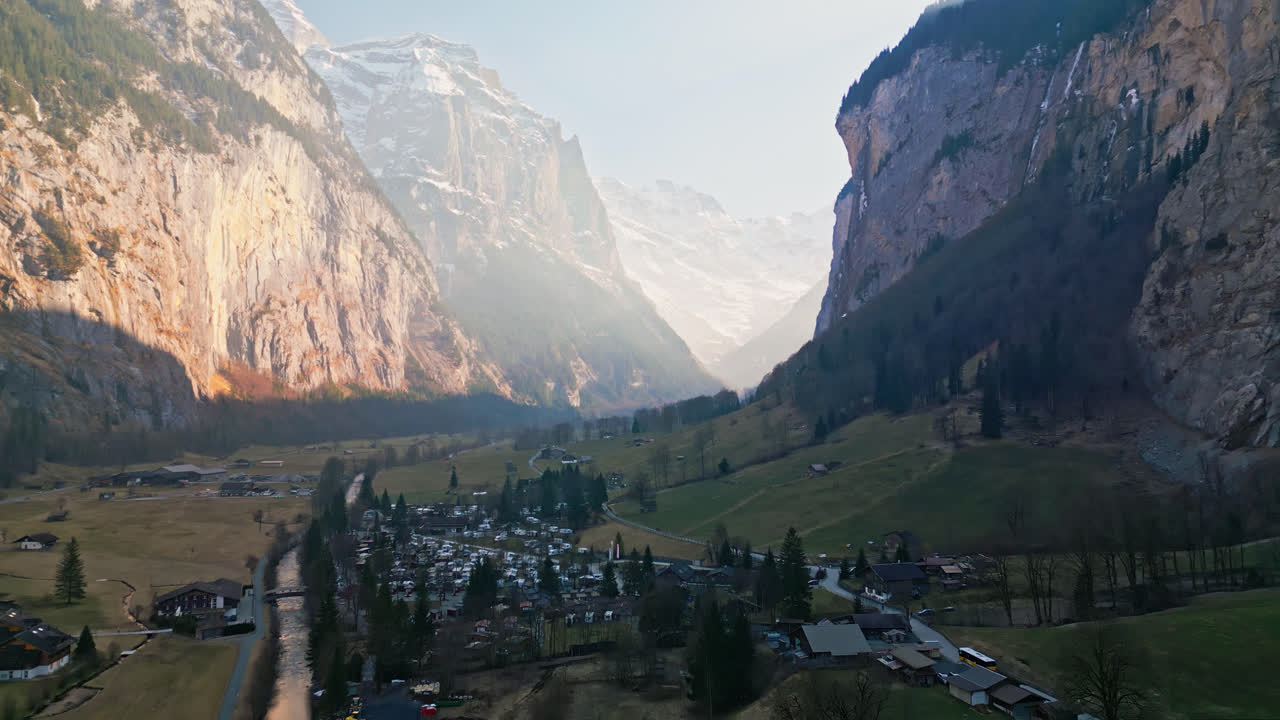 스위스 라우터브룬 ⁇ 의 집들은 협곡 아래로 흐르는 평온한 강을 가로지르고 있습니다.