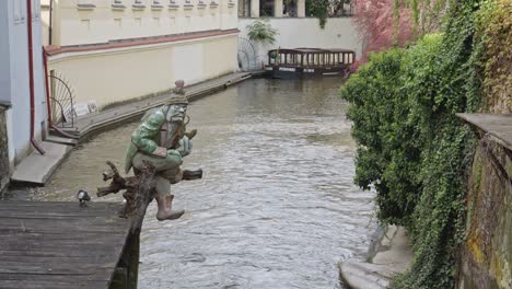 troll statue with a pipe in canal in old town city centre of prague, czech republic