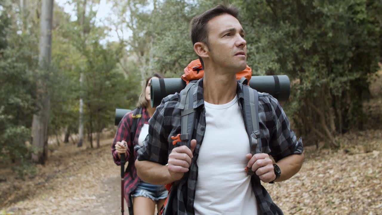 pareja de turistas activos mirando el paisaje
