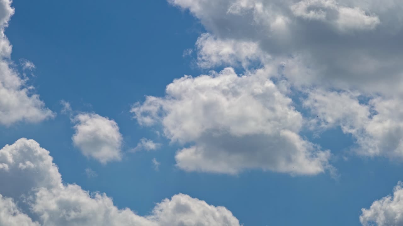 Clouds moving across a blue sky during daytime in the summer