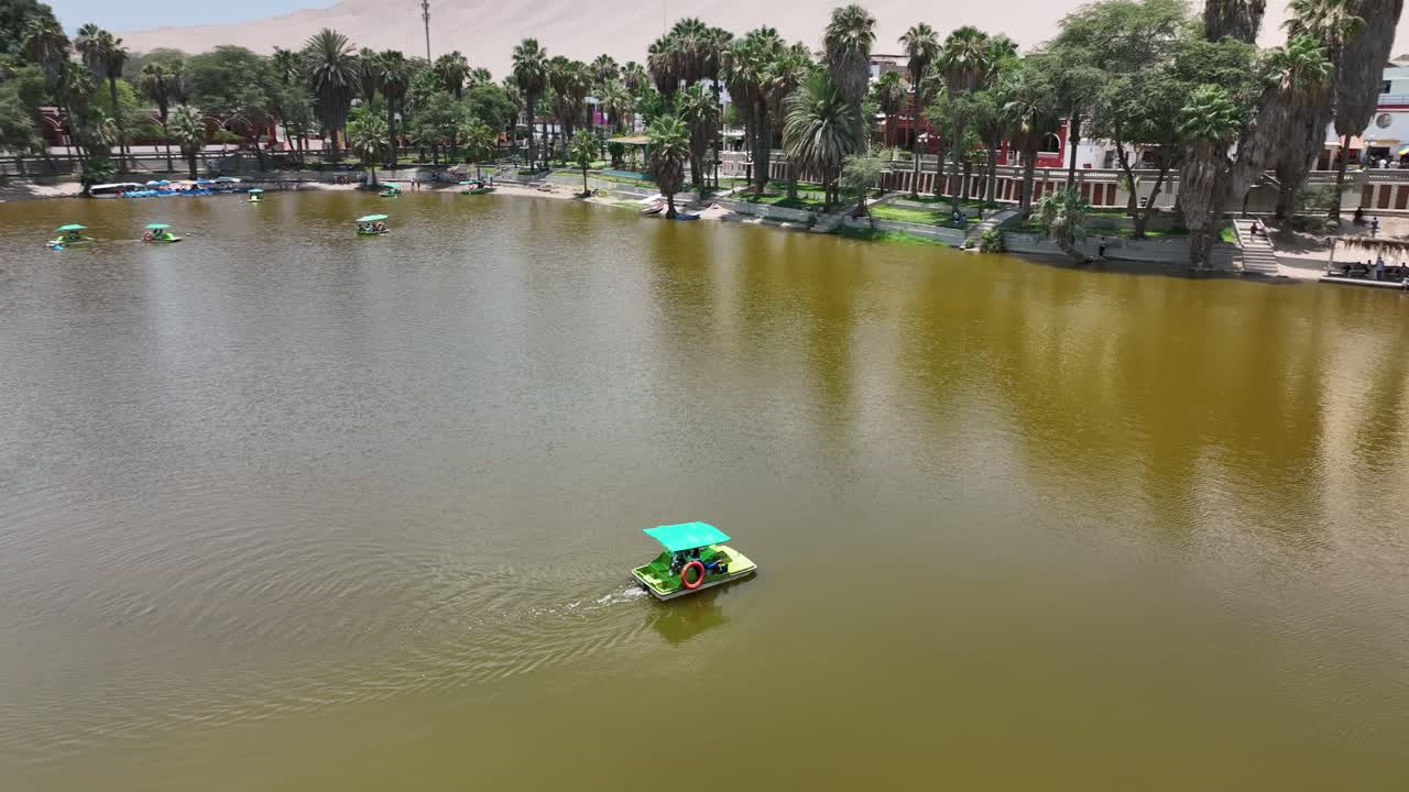 oasis del desierto huacachina, perú con lago y palmeras, con grandes dunas de arena en el fondo