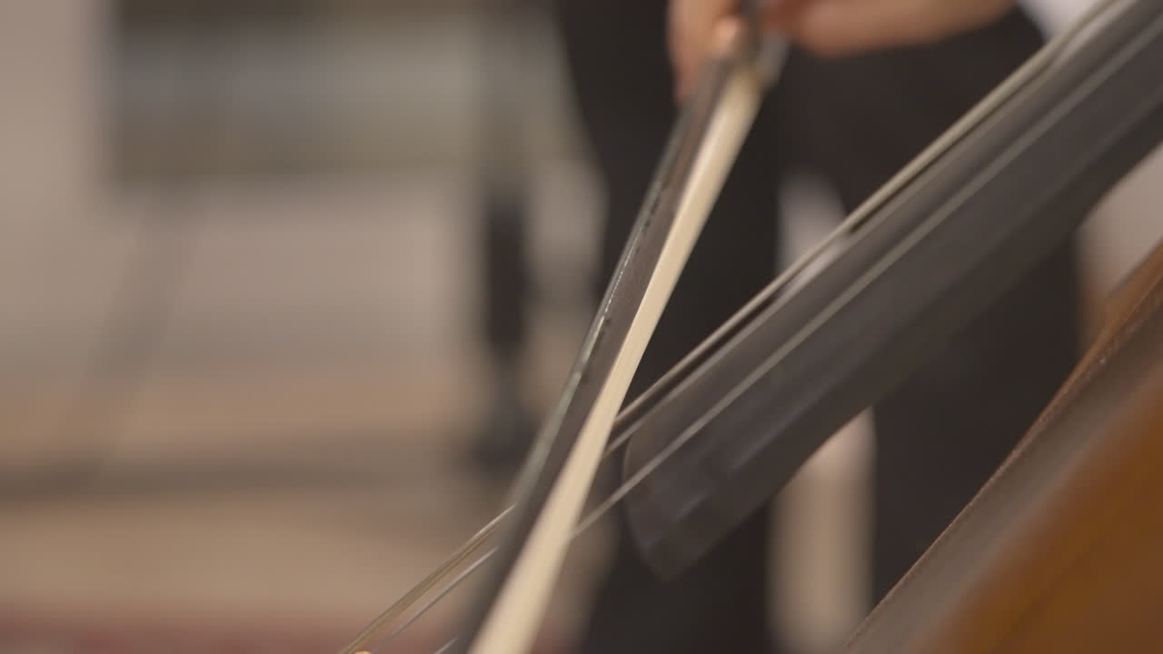 Primo piano di un musicista che suona il violoncello con un archetto