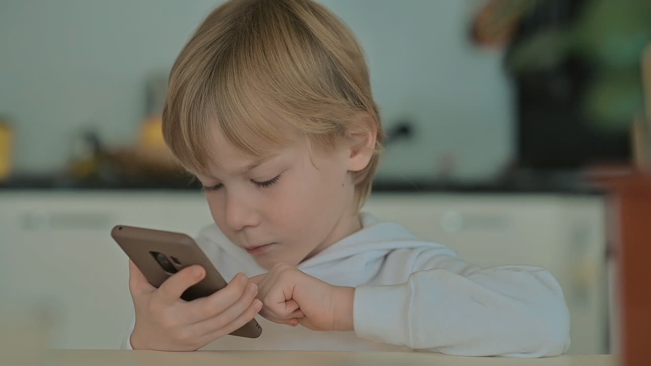 Criança com Celular Usando Aplicativos em Casa 1