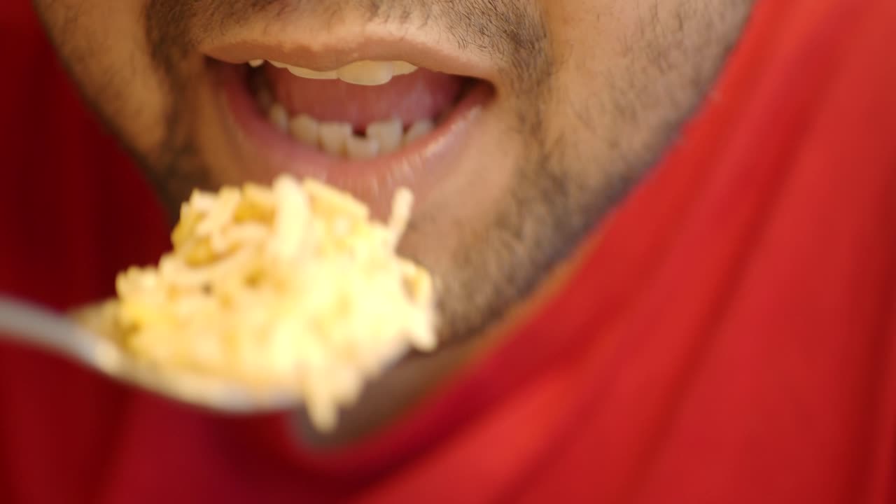 Close-up of a person eating rice with a spoon