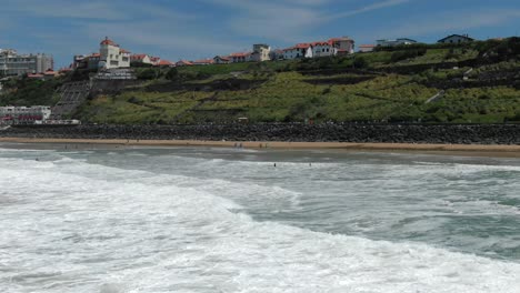 beach and cliffs, biarritz, france. aerial drone lateral view, low flight