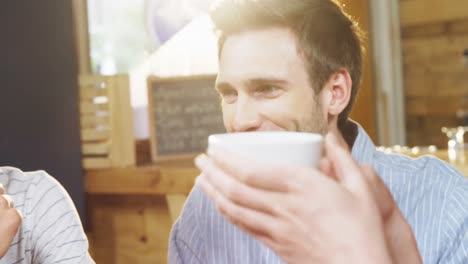 Group-of-friends-interacting-each-other-in-cafe-4k