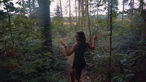 backward moving follow up shot of young happy beautiful girl grooving, dancing and enjoying her holiday in wilderness