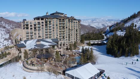 Beautiful-aerial-drone-shot-of-a-resort-and-roads-covered-with-snow-over-Park-City,-Utah,-USA-in-a-cold-wintry-morning-1