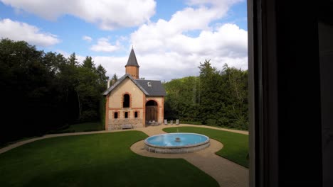 slow revealing shot of a renovated church with a beautiful garden and fountain