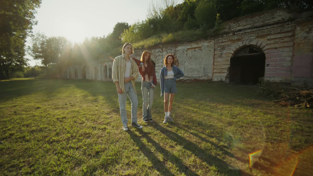 역사적인 유적 근처의 공원에서 포즈를 취하는 세 명의 친구