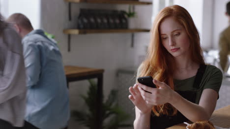 Joven-Mujer-De-Negocios-Usando-Un-Teléfono-Inteligente-En-Una-Cafetería-Tomando-Café-Navegando-En-Línea-Leyendo-Mensajes-De-Correo-Electrónico-En-Un-Teléfono-Móvil-Enviando-Mensajes-SMS-Disfrutando-De-La-Comunicación-Por-Teléfono-Celular