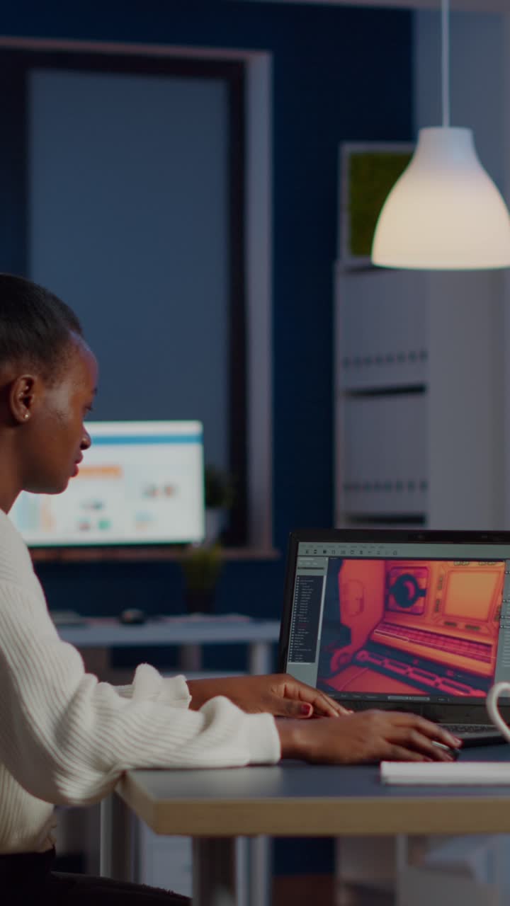 Vertical video Dark skin gamer developer working at video game in midnight