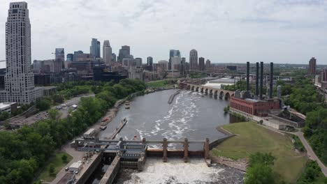 wide aerial descending shot of saint anthony falls on the mississippi river in downtown minneapolis, minnesota