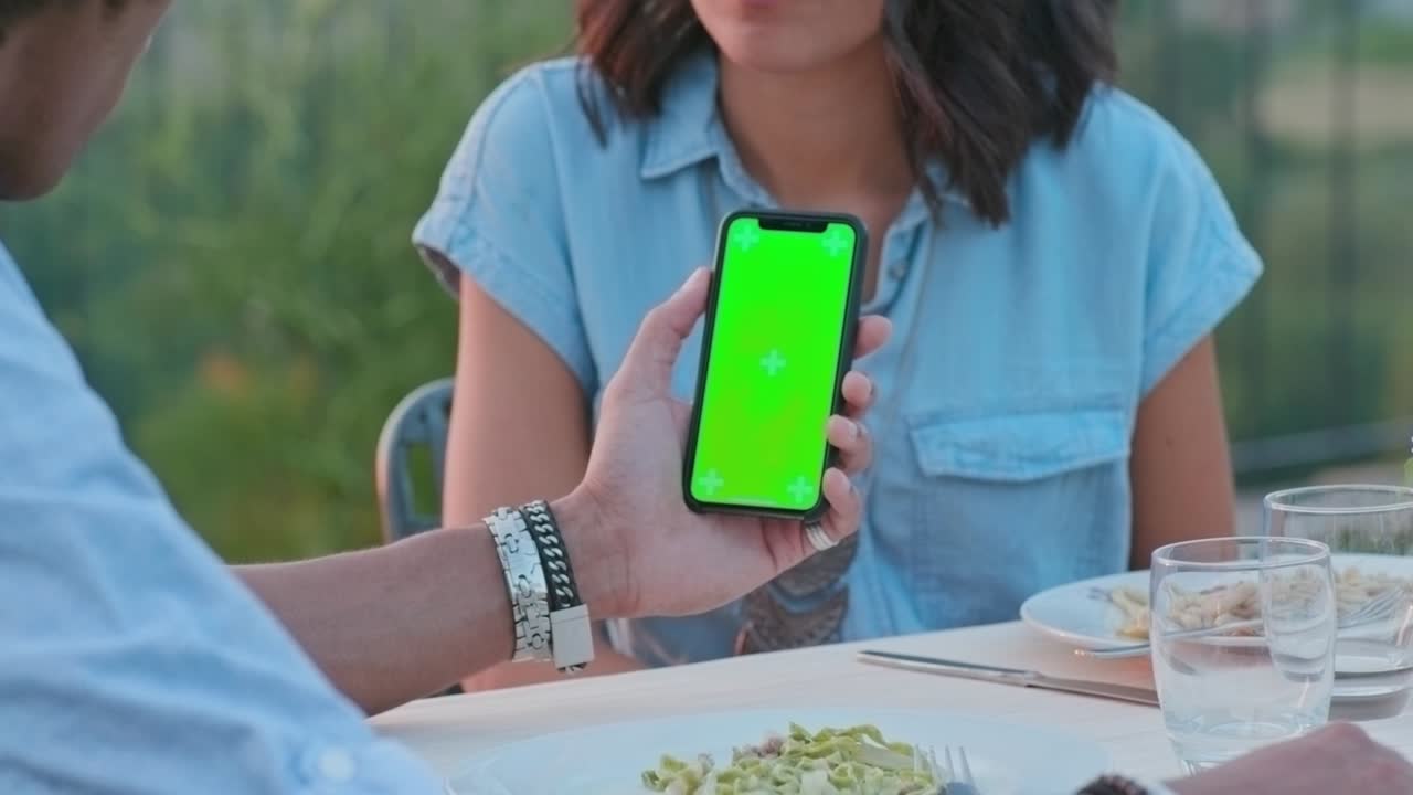hombre usando un teléfono inteligente de pantalla verde durante una cena romántica al aire libre al atardecer.amigos viaje italiano en umbria.4k cámara lenta