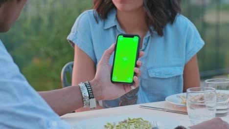 hombre usando un teléfono inteligente de pantalla verde durante una cena romántica al aire libre al atardecer.amigos viaje italiano en umbria.4k cámara lenta