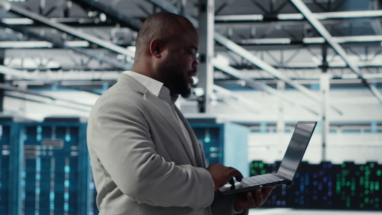 Vertical video Smiling data center programmer using laptop to upgrade system stability