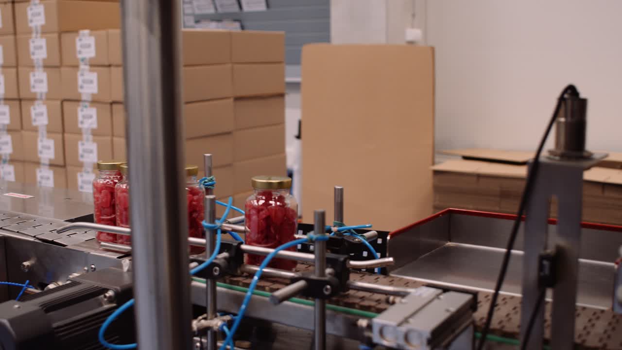 조립 라인의 병에 담긴 빨간 젤리 곰 종합 비타민 보충제, 팬 샷