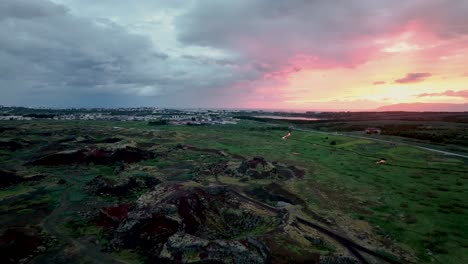 puesta de sol panorámica sobre los suburbios de reykjavík en islandia - toma aérea de un dron