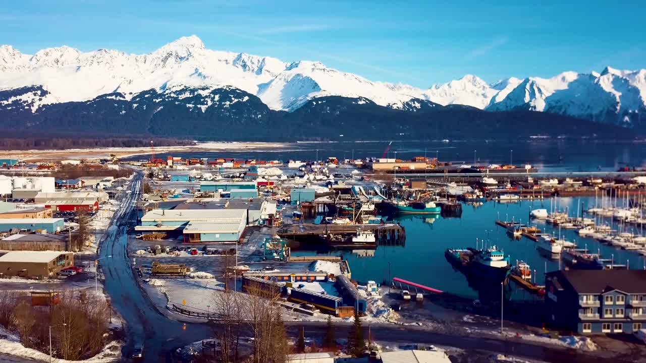 알래스카의 눈 내리는 겨울날 시워드 보트 항구와 주변의 눈 덮인 산을 보여주는 4k 드론 영상