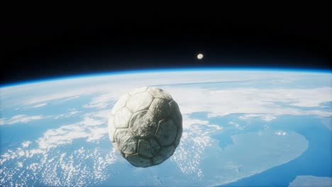 old soccer ball in space on earth orbit