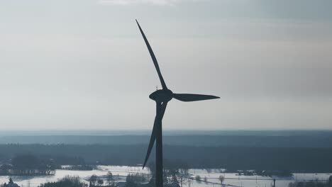 close-up view of a wind turbine's silhouette against a stark winter sky in the baltic region