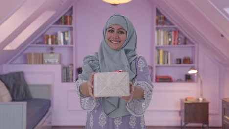 happy muslim woman giving a gift