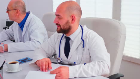 Close-up-of-healthcare-physician-checking-notes-on-clipboard