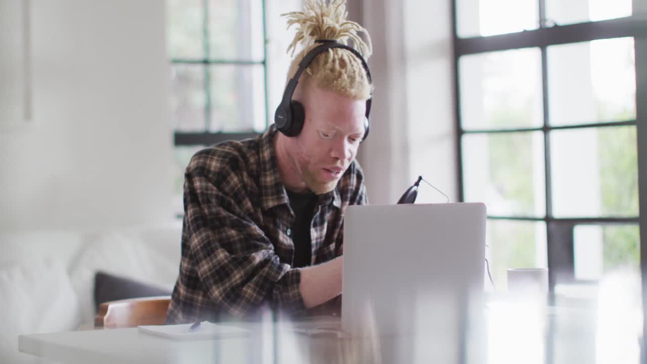 Happy albino african american man with dreadlocks making podcast