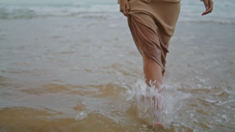 Die-Füße-Einer-Frau-Laufen-Abends-Im-Wasser,-Nahaufnahme.-Unbekannte-Dame-Tritt-Auf-Welliges-Meer