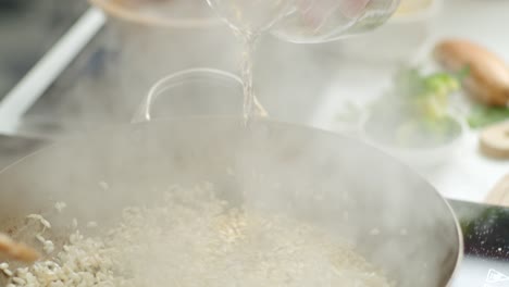 crop woman cooking risotto in pan in kitchen