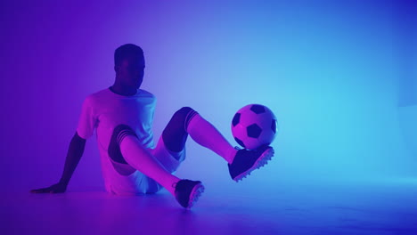 Black-african-man-Freestyle-or-professional-soccer-player-practicing-with-football-ball-juggling-on-legs-slow-motion.-Studio-shooting-of-a-professional-football-player-with-a-ball