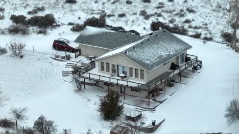 una foto de un avión no tripulado de una casa rural de dos pisos cubierta de nieve