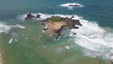 Drohne-In-Richtung-Einer-Felsigen-Landspitze-Mit-Weißen-Wellen,-Die-Durch-Felsen-Am-Sawtell-Beach-In-Der-Nähe-Der-Bonville-halbinsel-In-New-South-Wales,-Australien,-Spritzen