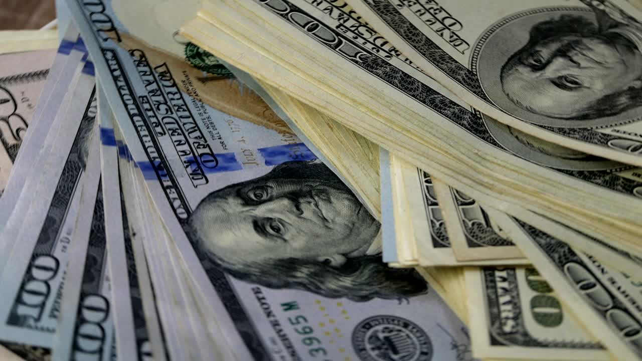 Billetes de cien dólares americanos, anverso hacia arriba, rotando en círculo