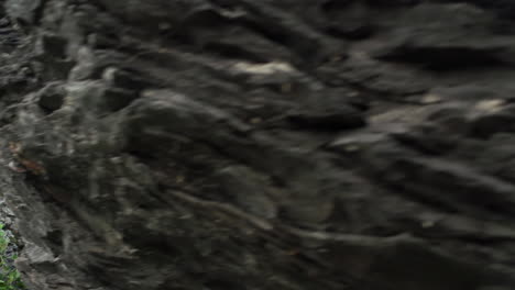 family hiking in the mountains, father helps his son and his wife get off a rock