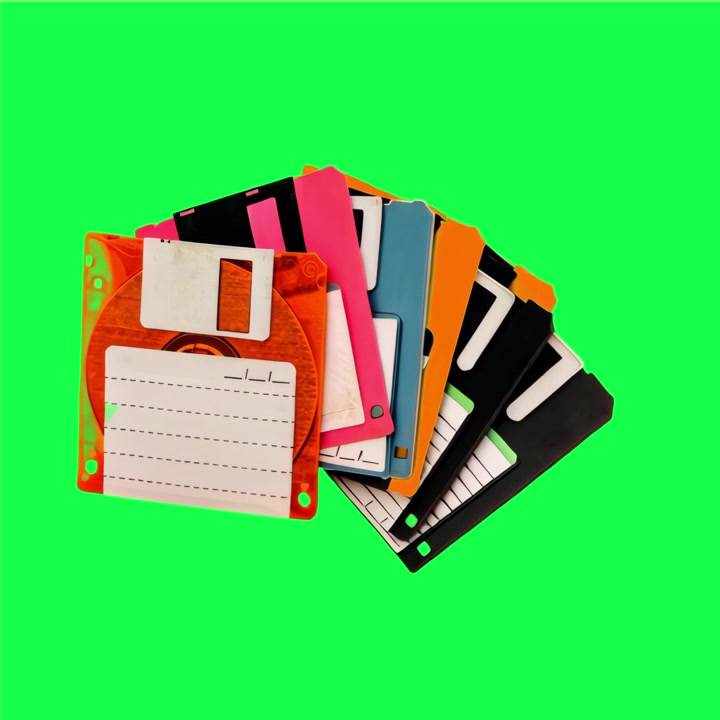 Pila di floppy disk vintage colorati su sfondo verde