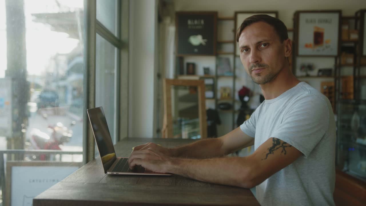 hombre trabajando en una computadora portátil en un café