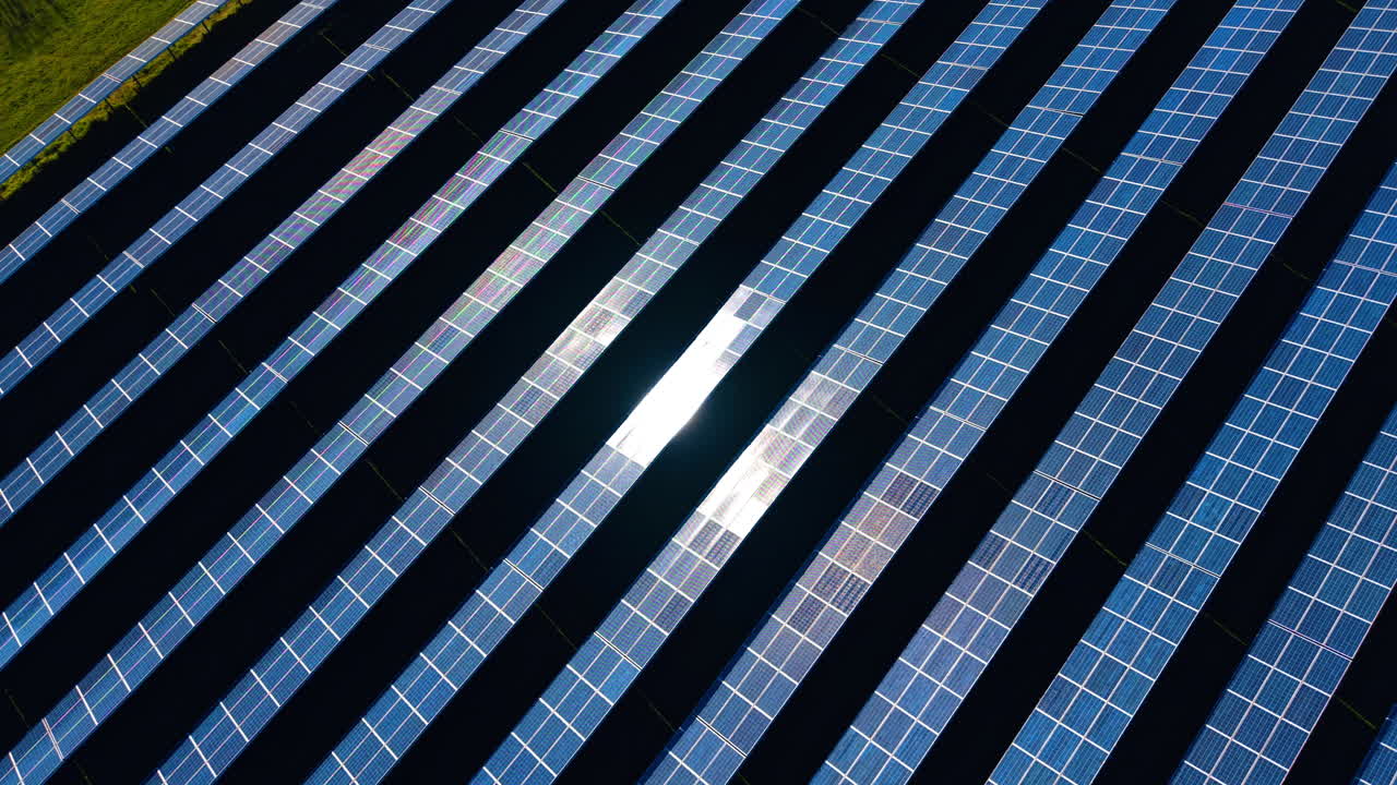 Padrão diagonal abstrato de painéis solares com reflexo do sol. Fileiras diagonais de painéis fotovoltaicos azuis com reflexo solar central intenso criando um padrão industrial geométrico.