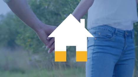 pareja cogida de la mano y casa llena de amarillo
